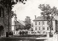Two storey brick building with cemetery in front